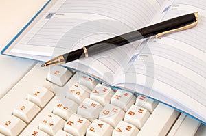 Notepad and pen on the keyboard