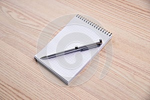 Notepad with pen on office wooden table