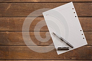 Notepad with pen on office wooden table.