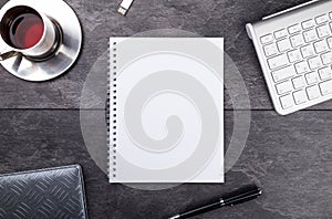 Notepad, pen, tea and keyboard on stone table