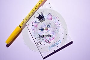 Notepad and pen. Yellow pen and notebook with a picture of a cat. Delicate notebook for notes for the girl. Place for notes.