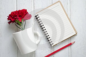 Notepad, pencil and Carnation flowers