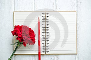 Notepad, pencil and Carnation flowers