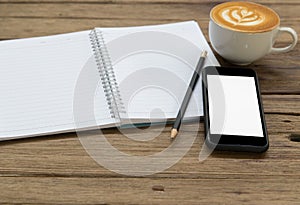 Notepad, pencil, coffee and mobile phone on wood table