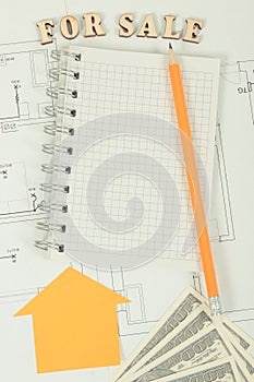 Notepad with pencil and dollar on housing plan, selling and buying house or flat concept