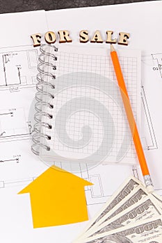 Notepad with pencil and dollar on housing plan, selling and buying house or flat concept