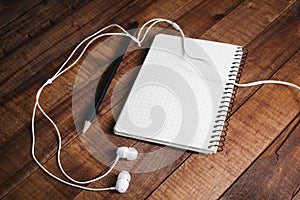 Notepad, pencil and headphones