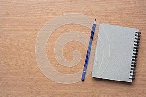 Notepad with pencil on wood board background.using wallpaper for