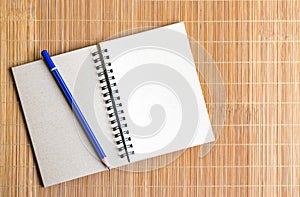 Notepad with pencil on wood board background. using wallpaper or background for education, business photo. Take note of the produc