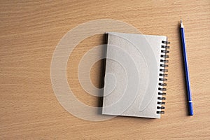 Notepad with pencil on wood board background.using wallpaper for education, business photo.Take note of the product for book with