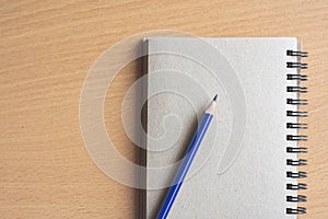 Notepad with pencil on wood board background.using wallpaper for education, business photo.Take note of the product for book with