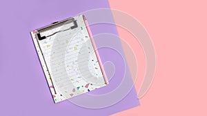notepad with a pencil for writing text. on a pink and lilac paper background