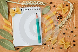 Notepad for recipes, pencil and decorative frame with pasta and spices
