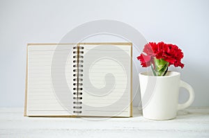 Notepad and red Carnation flower