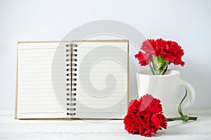 Notepad and red Carnation flower