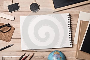 Notepad with school supplies, globe, notebook and blackboard on a wooden table. Top view. Space for text.  For back to school