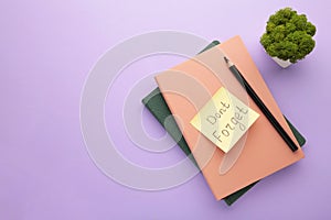 Notepad and sticky notes with word don`t forget on purple background