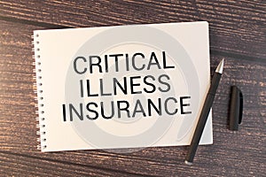 Notepad with text CRITICAL ILLNESS INSURANCE. Diagram and white background