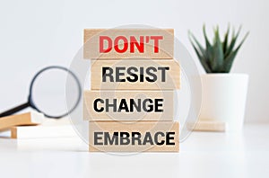 Notepad with text Dont resist change embrace on wooden block