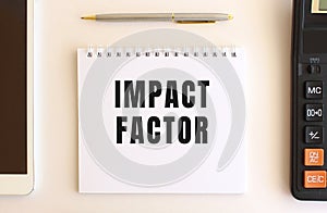 Notepad with text IMPACT FACTOR on a white background. Business concept