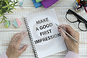 Notepad with text MAKE A GOOD FIRST IMPRESSION . White background.