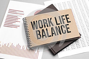 Notepad with text work life balance on a white background, near laptop, calculator and office supplies. Business concept