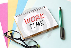 The Notepad with the text Work Time is on colored paper with glasses and a pen