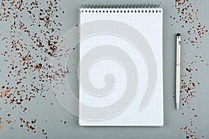 Notepad with white sheets and pen on a gray background