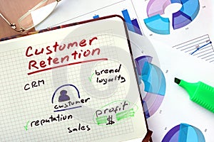 Notepad with words customer retention strategies.