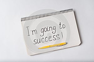 Notepad with the words Im going to success on white background. Handwritten