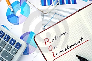 Notepad with words ROI return on investment concept.