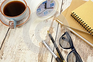 Notepads, calculator and a cup of coffee on a retro wooden table