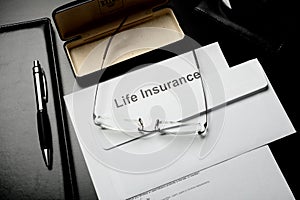 Notepads, glasses and life insurance papers