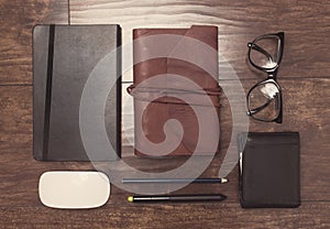 Notepads in leather cover with pencils and eyeglasses