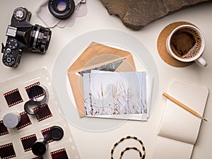 Notes with a cup of hot coffee and various photo accessories
