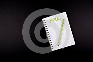 Notes, green pen and a open notebook