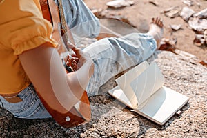 Notes,lyrics in the book on stone at parks beside women play guitar photo