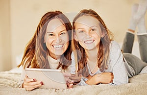 Nothing beats mother and daughter time. an attractive young mother lying on the bed at home and bonding with her