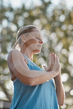 Nothing can brake my focus. a mature and fit woman engaging in a upwards yoga pose with her hands together.