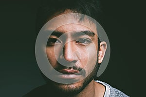 Is nothing an emotion because I feel that. Studio shot of a young man staring blankly against a dark background.