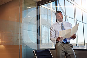 Nothing feels better than succeeding. a young male lawyer standing by his desk in the office.