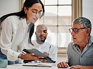 Nothing gets ideas churned out like good old teamwork. a group of businesspeople using a digital tablet during a meeting