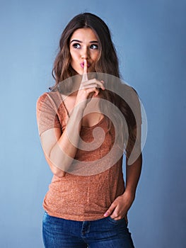 Nothing haunts us like the things we dont say. Studio shot of an attractive young woman posing with her finger on her