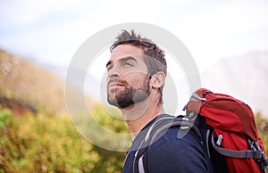 Nothing like the feeling of fresh air on your face. a young man enjoying a hike through the mountains.