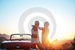 Nothing like a getaway to reaffirm the romance. an affectionate senior couple enjoying the sunset during a roadtrip.