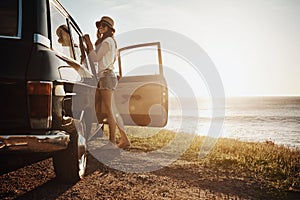 Nothing quite as relaxing as a road trip. Portrait of a young woman enjoying a road trip along the coast.