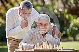 Nothing tests your mental muscle like chess. Shot of two senior men playing a game of chess outside.