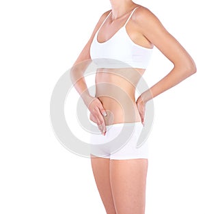 Nothing to worry about. Cropped studio shot of a woman measuring her waistline isolated on white.