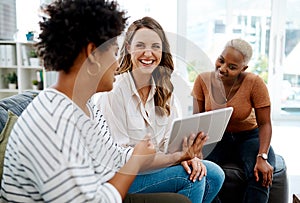 Nothing will stop this dedicated team. a group of businesswomen working together on a digital tablet in an office.