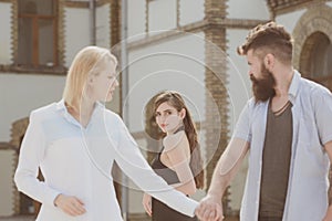 He is nothing but a womanizer. Hipster choosing between two women. Bearded man looking at other girl. Betrayal and photo